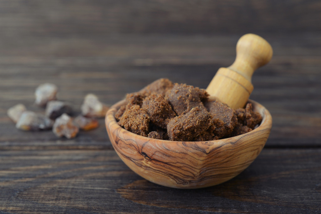 Muscovado sugar in bowl on wooden background